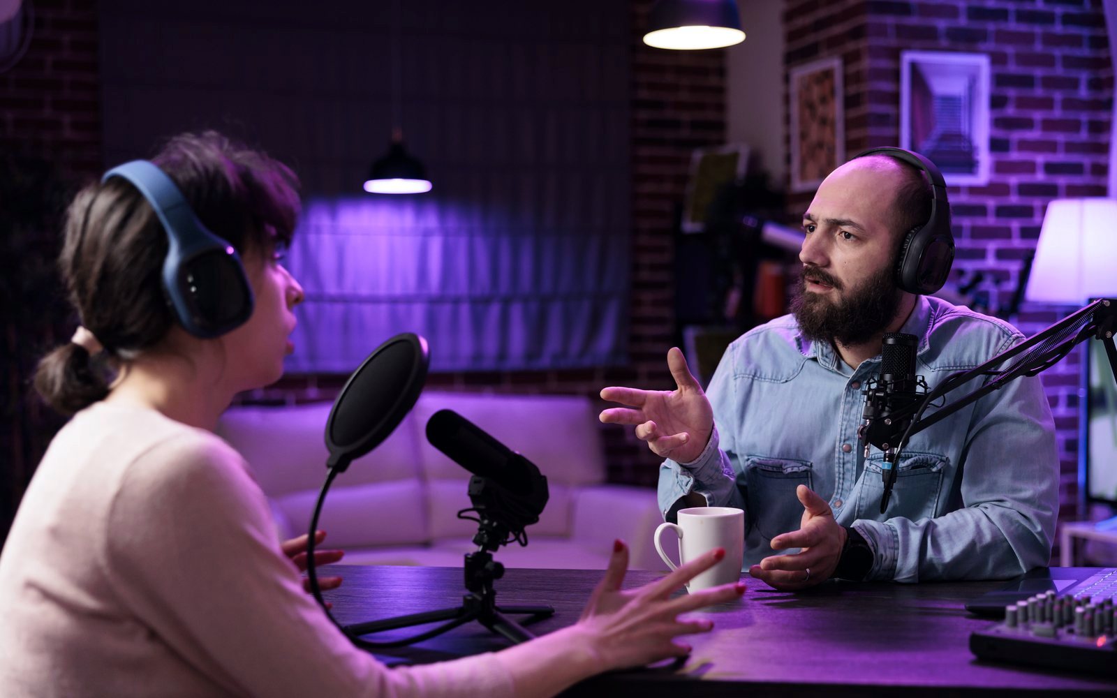 Dos personas grabando un pódcast con micrófonos y auriculares