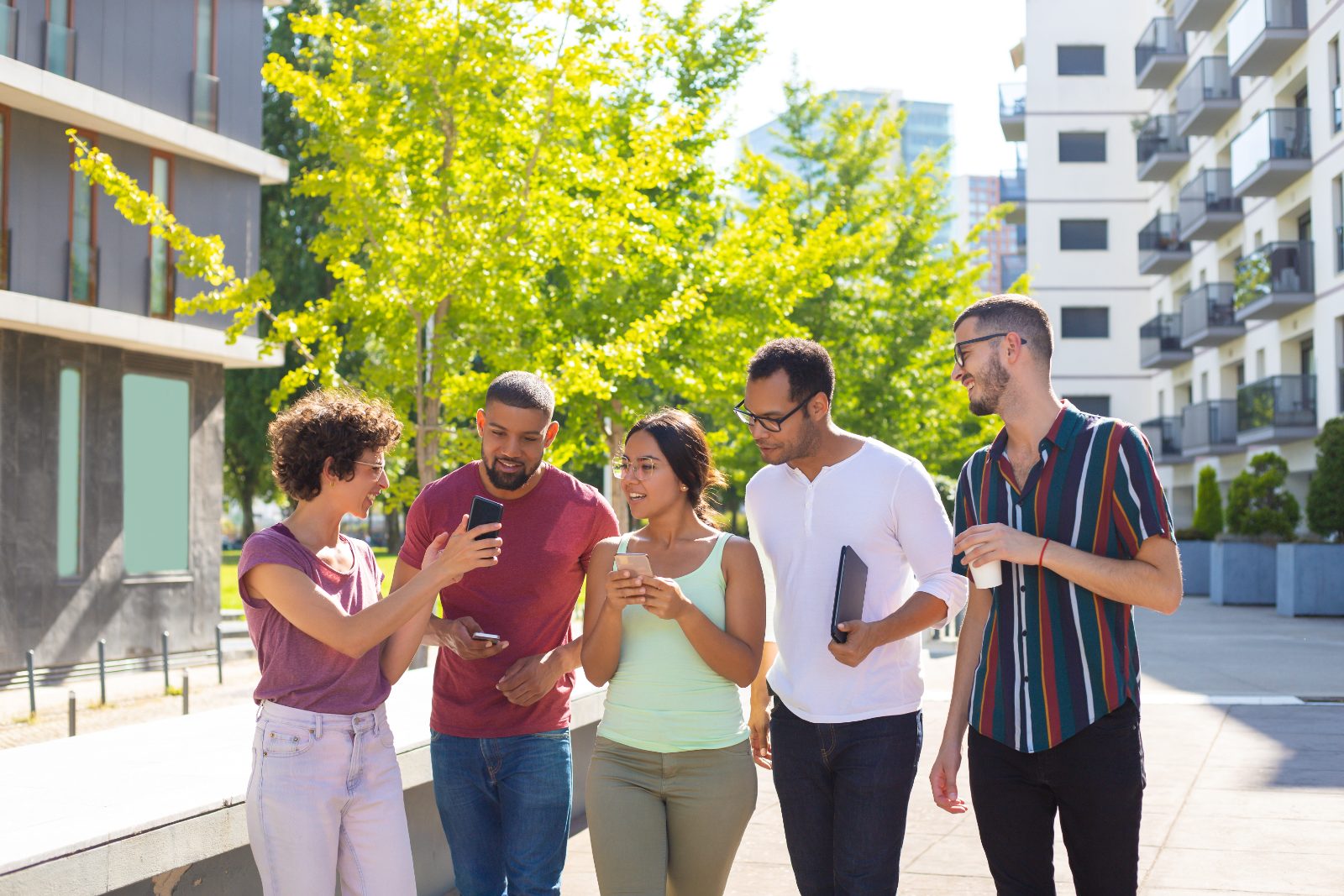 Grupo de jóvenes compartiendo contenido desde el móvil en la calle