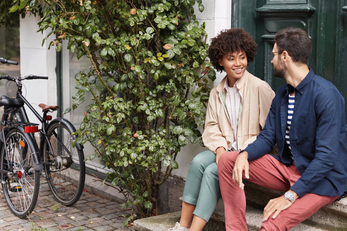 Dos personas conversando sentadas en la calle